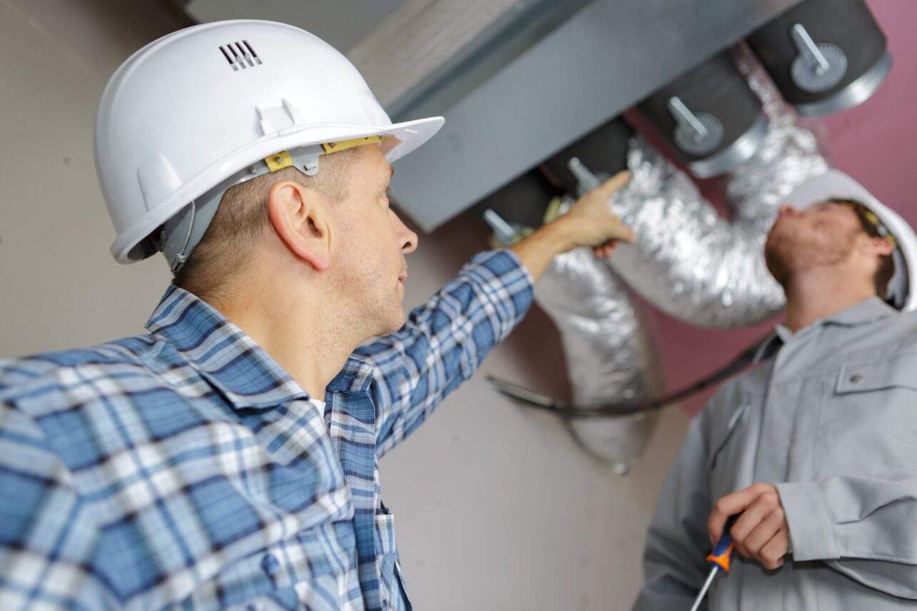 manager giving orders to coworkers fixing air conditioning