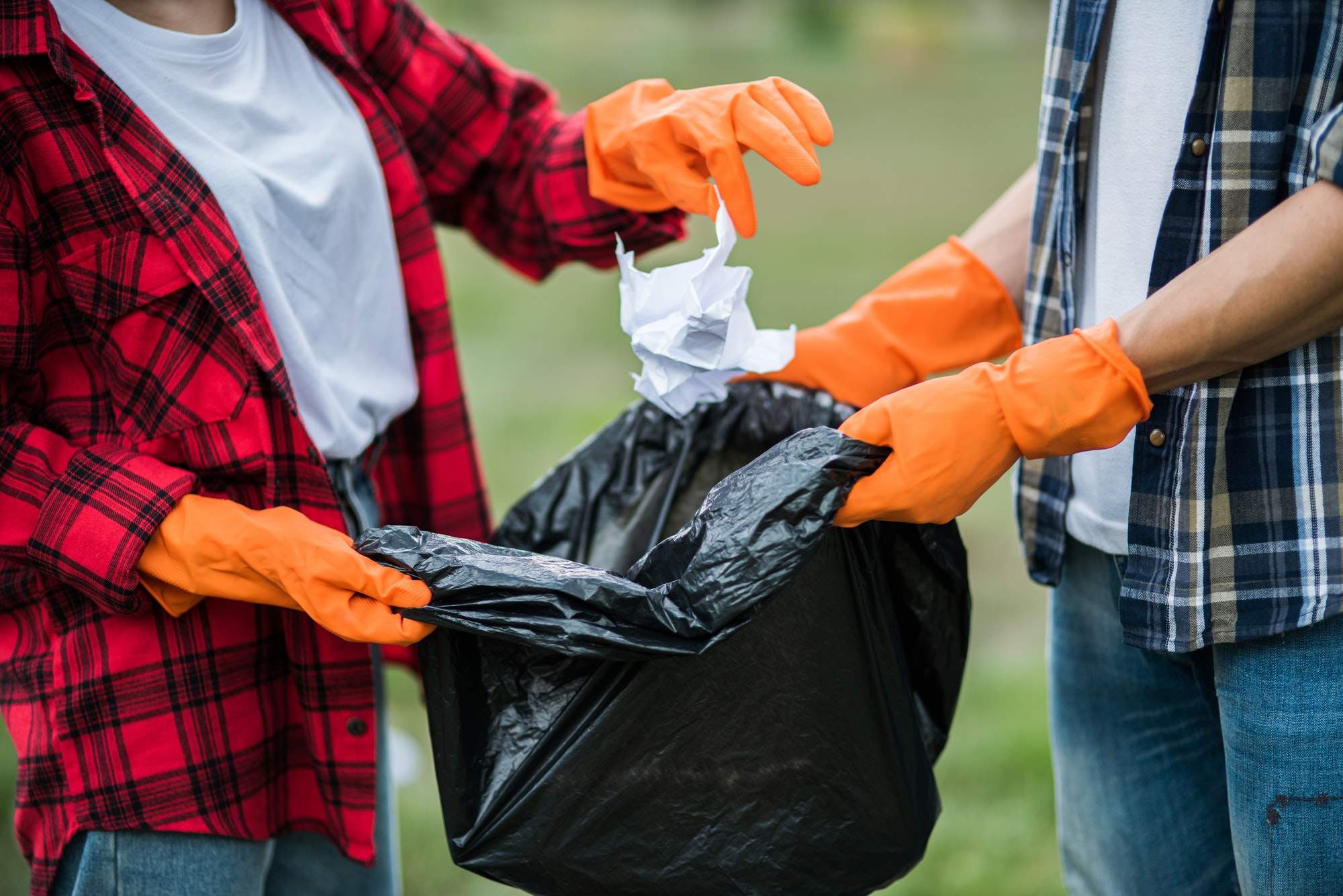 Men and women help each other to collect garbage.